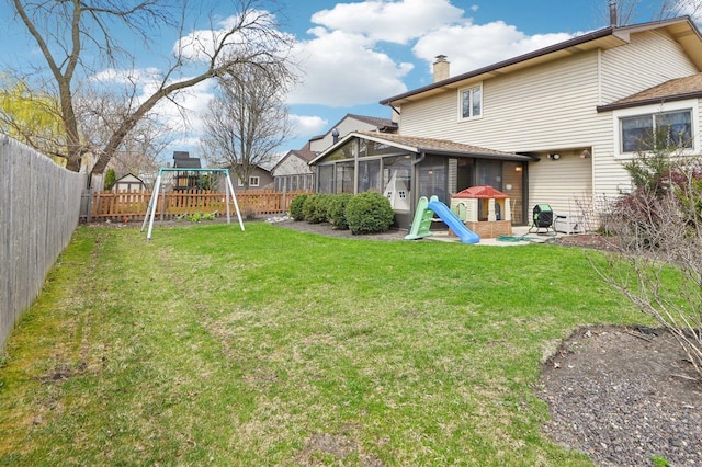 4569 Gettysburg Dr, Rolling Meadows, IL 60008 - rear view of property with a sunroom, a fenced backyard, a chimney, a playground, and a lawn