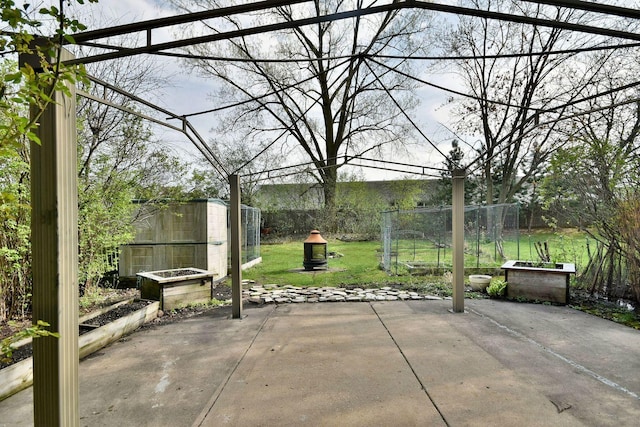 view of patio / terrace with a storage shed, fence, an outdoor structure, and a vegetable garden