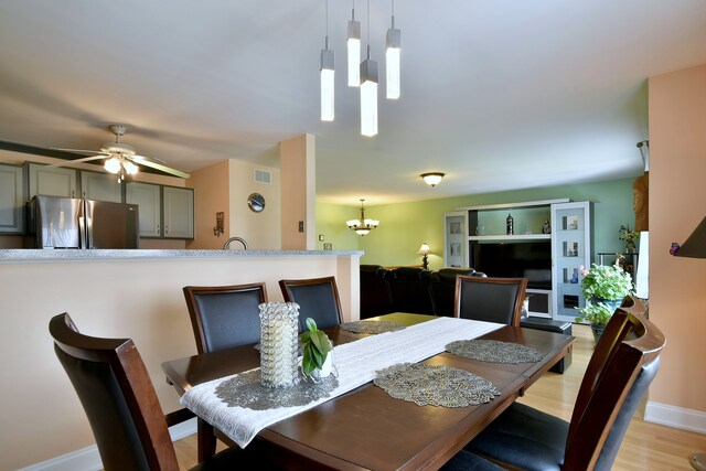 1923 Windward Ln Unit 1923, Hanover Park, IL 60133 - dining room with baseboards, ceiling fan with notable chandelier, light wood finished floors, and visible vents