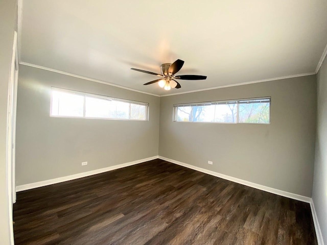 empty room featuring dark wood-type flooring, ornamental molding, baseboards, and ceiling fan
