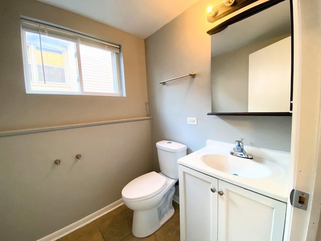 half bathroom with toilet, tile patterned floors, and vanity