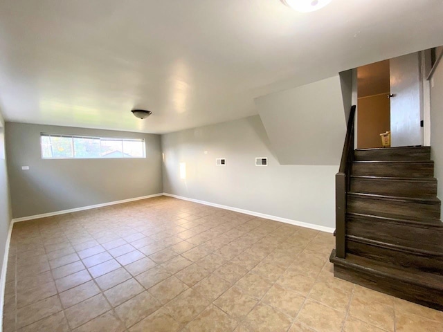 unfurnished room with baseboards, light tile patterned floors, visible vents, and stairway