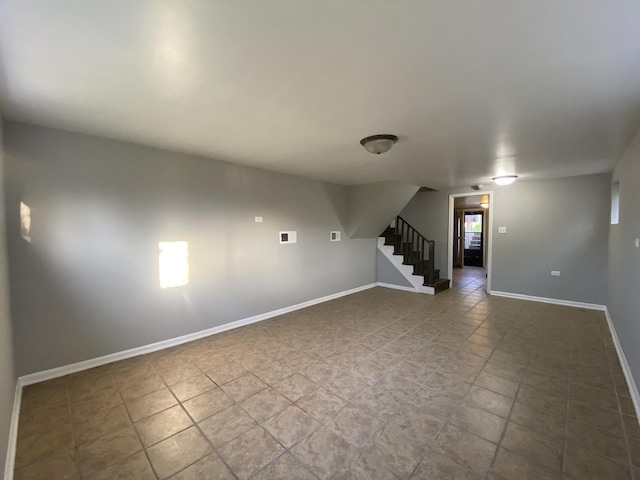 basement featuring stairway and baseboards