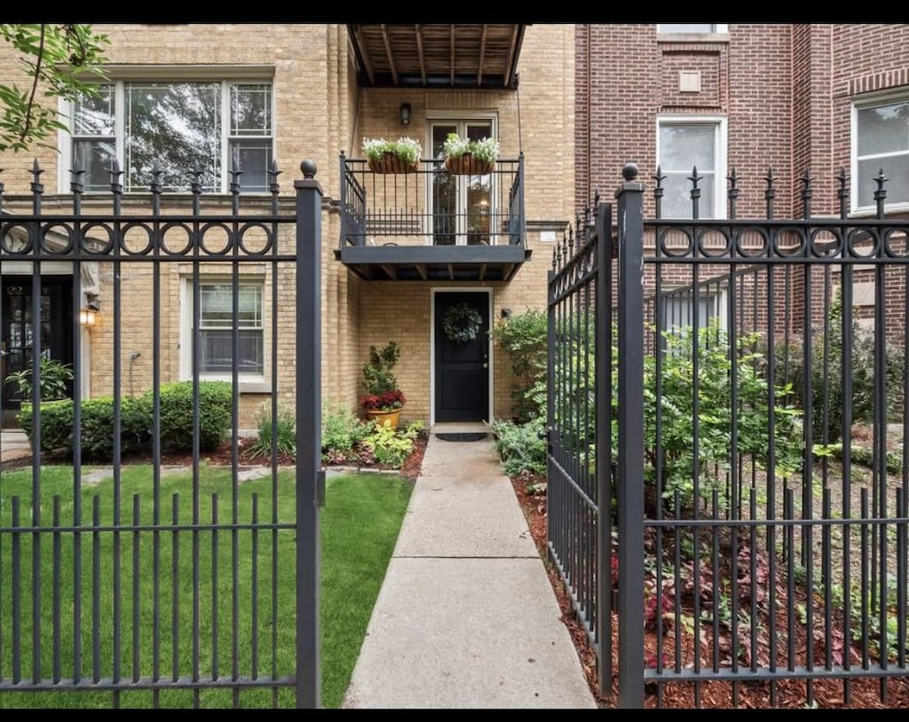 1210 W Roscoe St Unit G, Chicago, IL 60657 - exterior space with a front yard, a gate, brick siding, fence, and a balcony