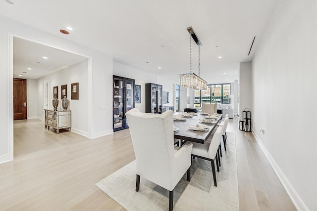 dining space featuring light wood-style floors, recessed lighting, and baseboards