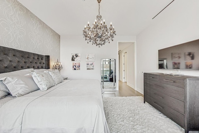 bedroom featuring baseboards, wood finished floors, and a chandelier