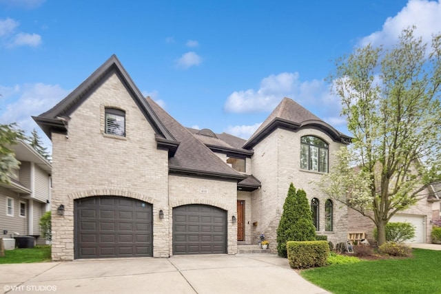 410 W 2nd St, Elmhurst, IL 60126 - french country inspired facade with a shingled roof, stone siding, brick siding, a front yard, and driveway