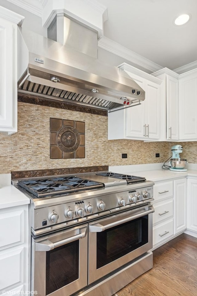 410 W 2nd St, Elmhurst, IL 60126 - kitchen featuring white cabinets, light countertops, wall chimney exhaust hood, range with two ovens, and tasteful backsplash