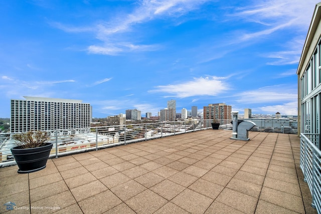 view of patio with a view of city and a balcony