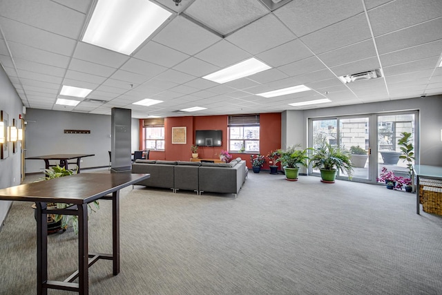 carpeted living area featuring visible vents and a drop ceiling