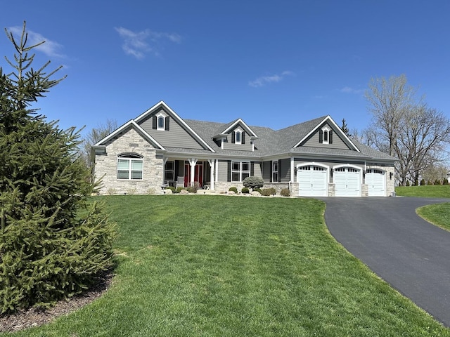 craftsman-style home featuring a front yard, a garage, stone siding, and driveway