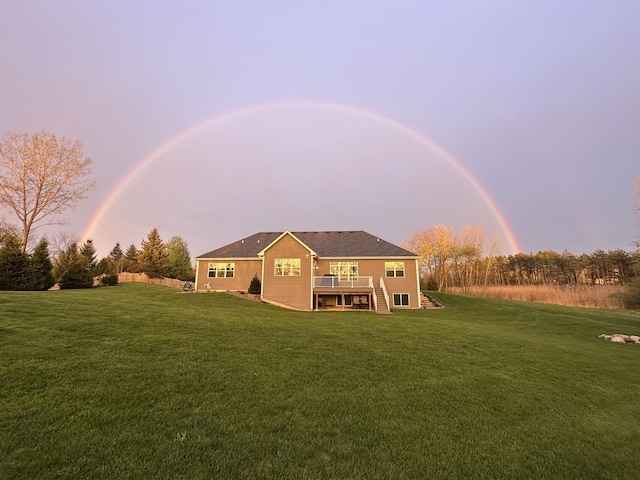 back of property at dusk with a yard