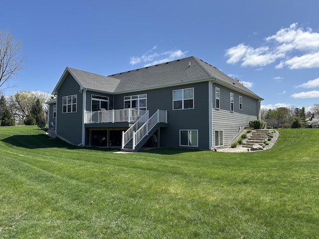 rear view of house with a yard, stairway, and a deck