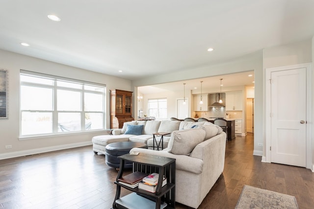 living area featuring dark wood-type flooring, baseboards, and recessed lighting