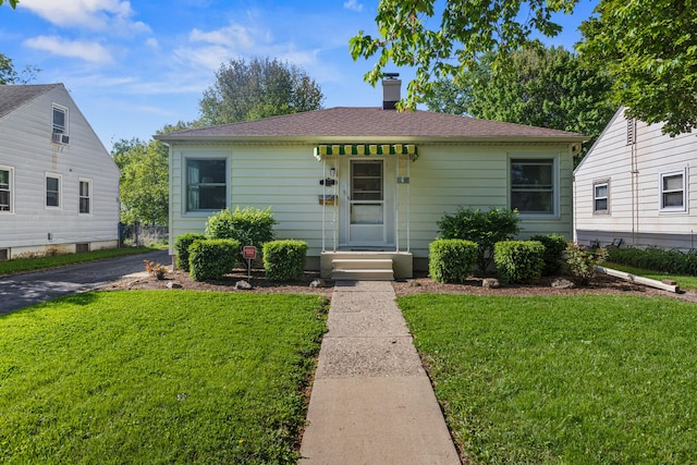 bungalow-style home featuring a front lawn and a chimney