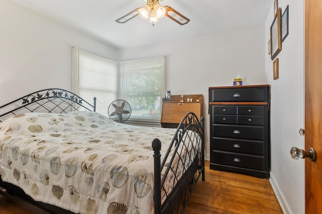 bedroom with wood finished floors, baseboards, and a ceiling fan