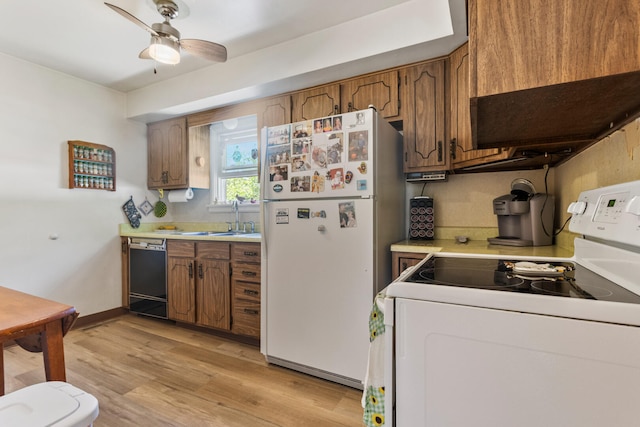 kitchen with white appliances, a sink, light countertops, light wood-style flooring, and a ceiling fan