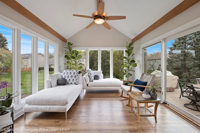sunroom featuring wood finished floors and high vaulted ceiling