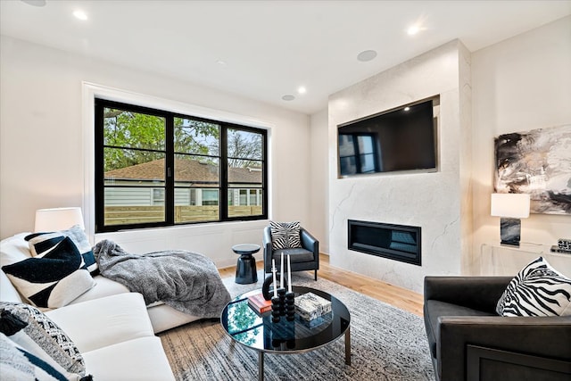 living room with a fireplace, recessed lighting, and wood finished floors