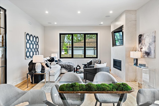 living room featuring a fireplace, recessed lighting, light wood-style flooring, and visible vents