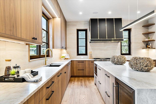 kitchen with a sink, range hood, light wood-type flooring, wine cooler, and modern cabinets