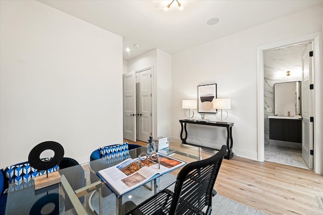 office space with baseboards and light wood-style floors