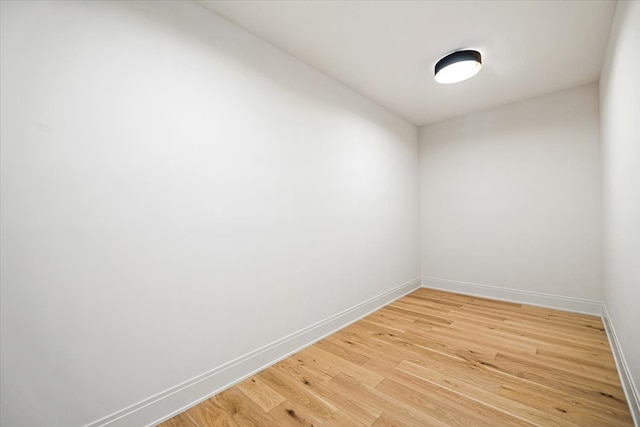 empty room featuring baseboards and light wood finished floors