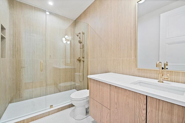 full bath with vanity, toilet, tile walls, tile patterned floors, and a stall shower
