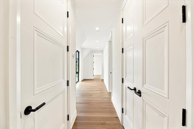 corridor featuring recessed lighting, baseboards, and light wood finished floors