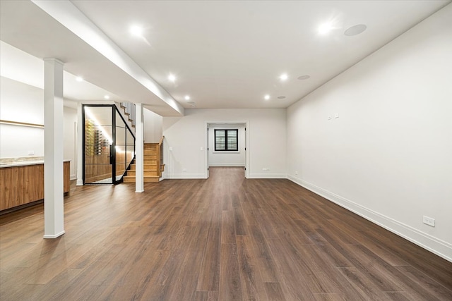 basement featuring stairway, baseboards, recessed lighting, and dark wood-type flooring