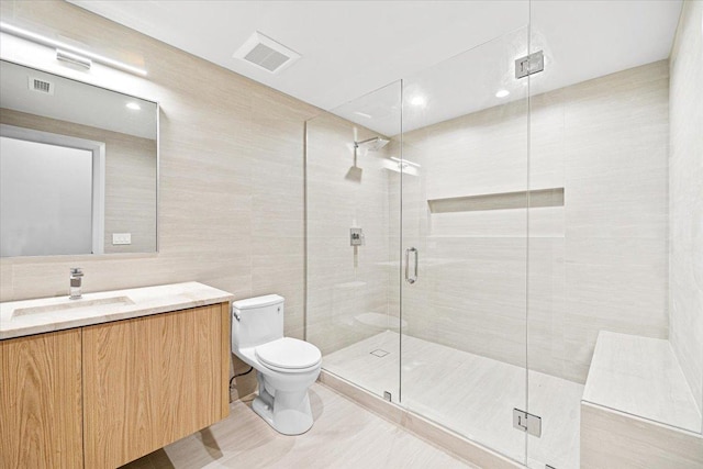 bathroom featuring vanity, toilet, tile walls, a shower stall, and visible vents
