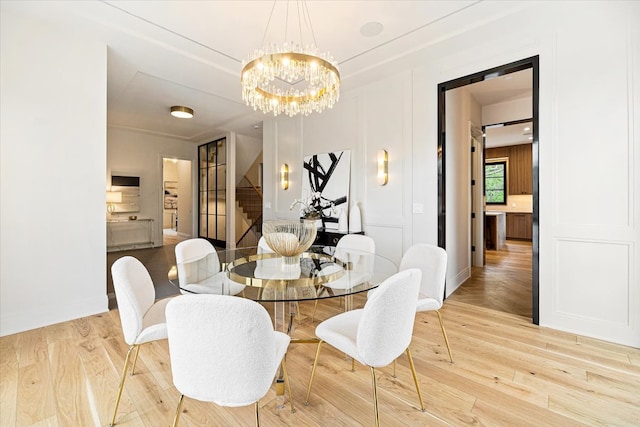 dining space with stairway, baseboards, wood finished floors, and a notable chandelier