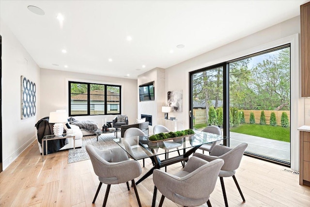 dining room featuring a fireplace, recessed lighting, visible vents, and light wood-style floors
