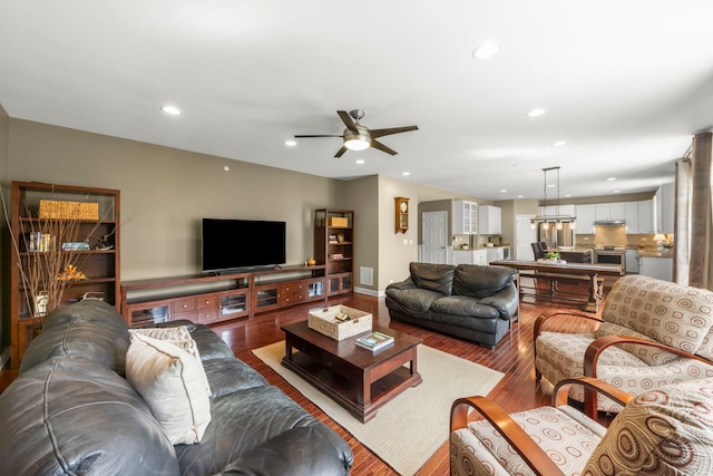 living area featuring baseboards, recessed lighting, ceiling fan, and wood finished floors