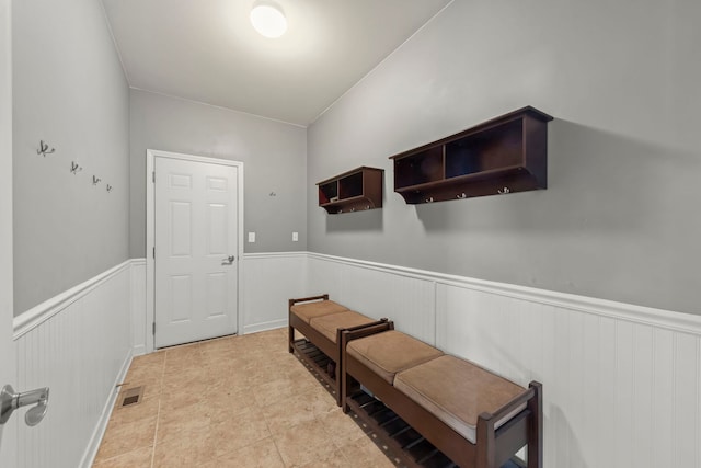 doorway to outside with wainscoting and visible vents