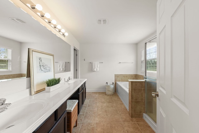bathroom featuring a sink, a wealth of natural light, and a garden tub