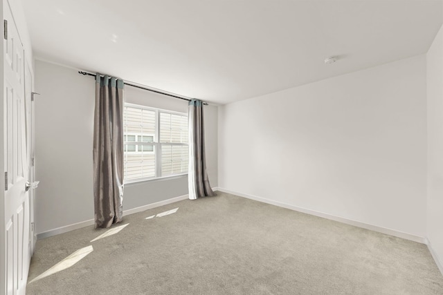 carpeted spare room with baseboards