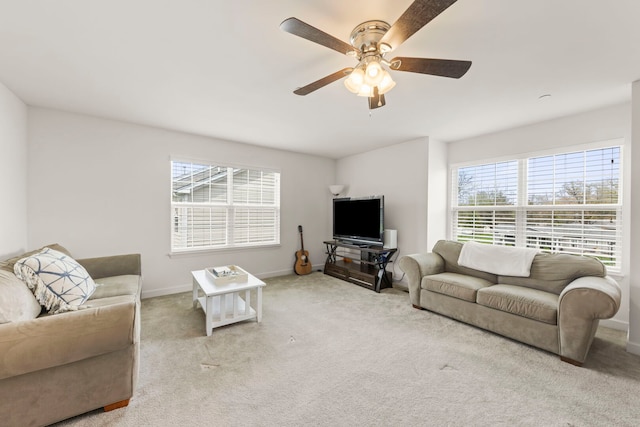 living room with a ceiling fan, baseboards, and carpet