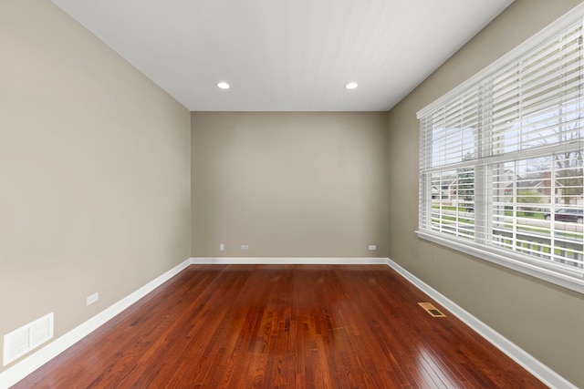 spare room with baseboards, dark wood-type flooring, recessed lighting, and visible vents