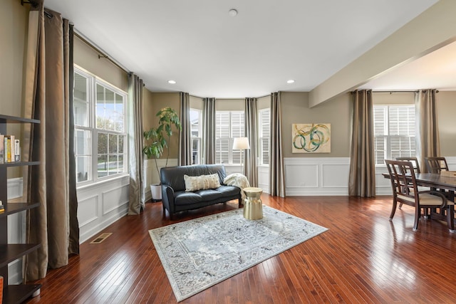sitting room featuring visible vents, a decorative wall, recessed lighting, a wainscoted wall, and dark wood finished floors