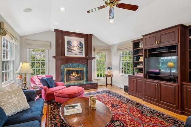 living room with lofted ceiling, a healthy amount of sunlight, and light wood-type flooring