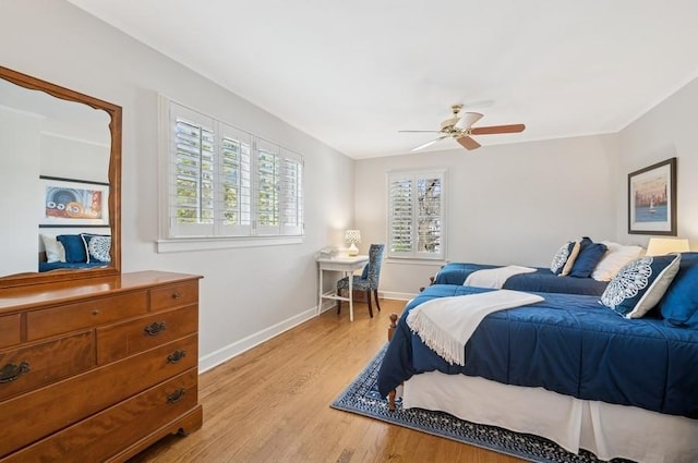 bedroom featuring multiple windows, light wood finished floors, baseboards, and ceiling fan