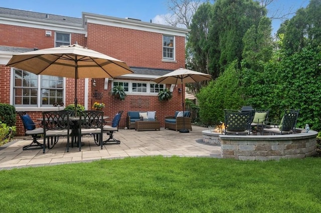 rear view of property with a yard, an outdoor living space with a fire pit, a patio, and brick siding