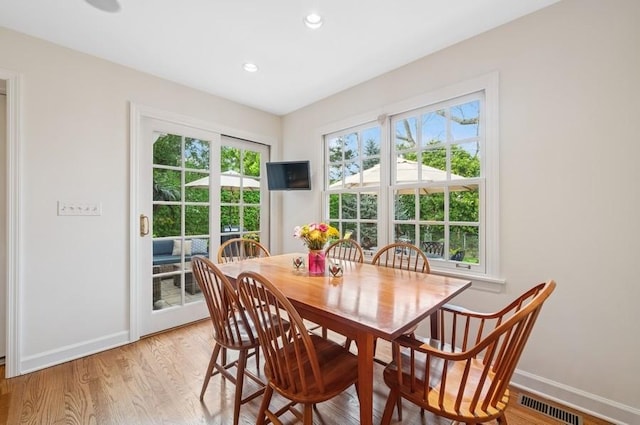 dining space with light wood finished floors, baseboards, and visible vents