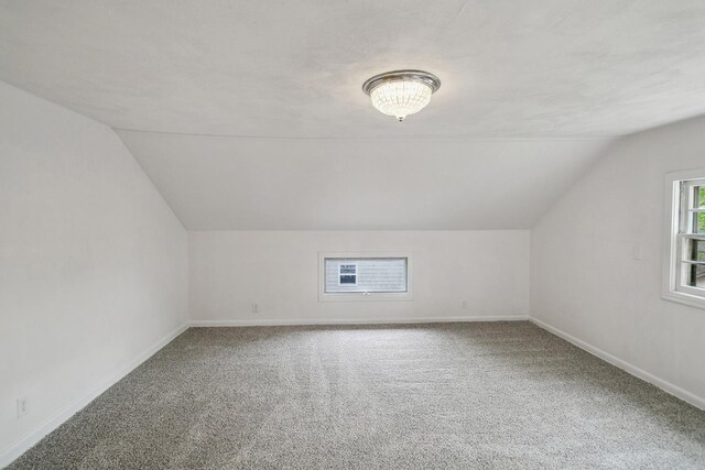 bonus room with baseboards, carpet flooring, and lofted ceiling