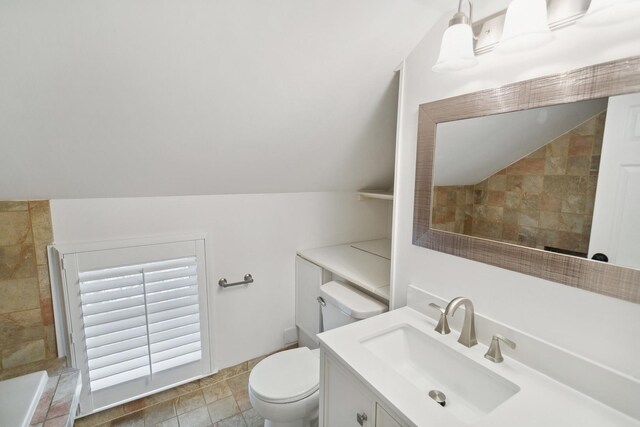 full bath featuring toilet, vaulted ceiling, a tile shower, and vanity