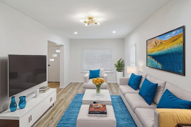 living room with recessed lighting, baseboards, an inviting chandelier, and light wood-type flooring