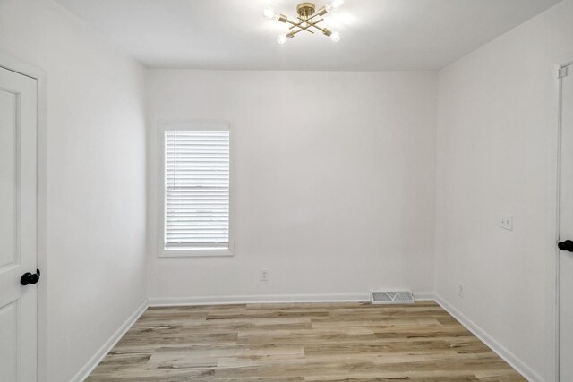 unfurnished room featuring light wood-style floors, baseboards, and visible vents