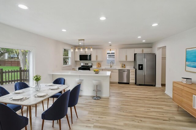 dining area with recessed lighting, baseboards, and light wood-style flooring
