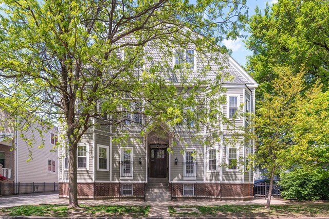 view of front of house with fence and brick siding